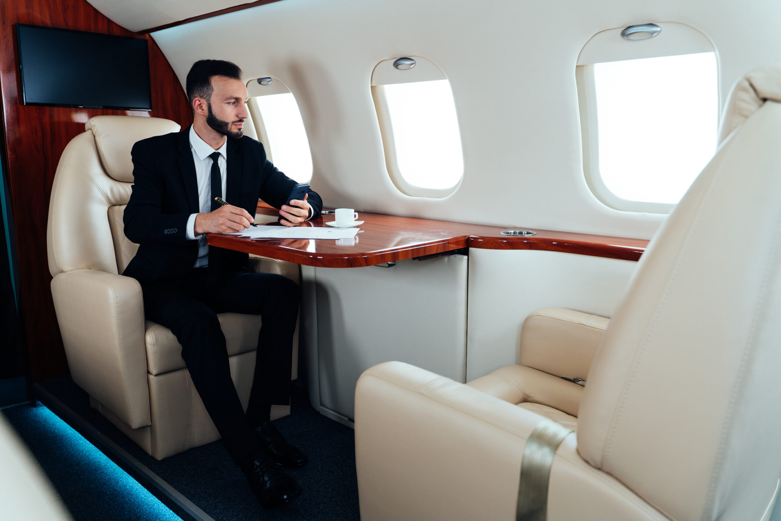 young man sitting airplane scaled - Excel Jet